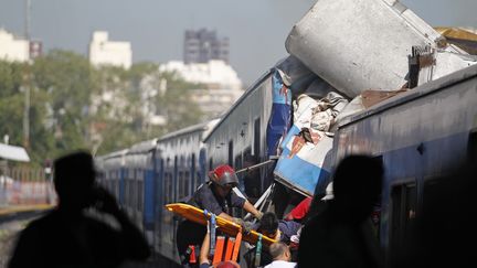 Les secours extraient des victimes de la carcasse du train qui a percut&eacute; l'avant du quai d'une gare de Buenos Aires (Argentine), le 22 f&eacute;vrier 2012.&nbsp; (ENRIQUE MARCARIAN / REUTERS)