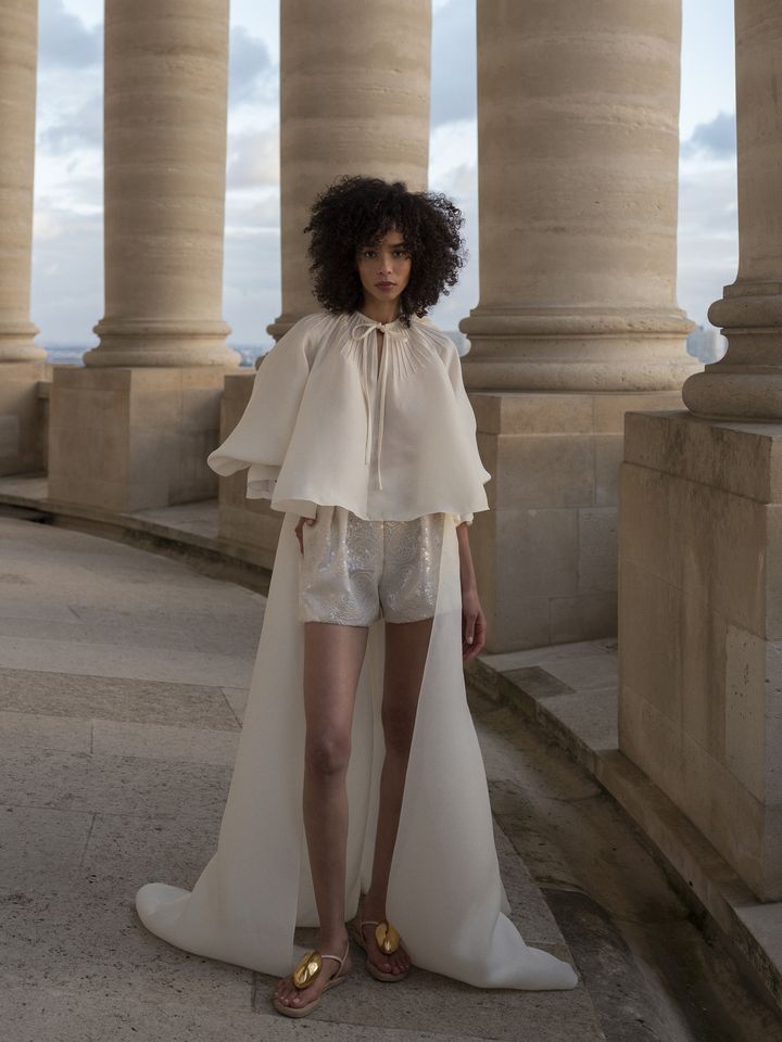 La mannequin Zuleica Eliana porte un short en paillettes ivoires avec une blouse-trench nervuré en gaze craie de la collection couture printemps-été 2022 de Christophe Josse au Panthéon à Paris, janvier 2022 (Cécile Bortoletti)