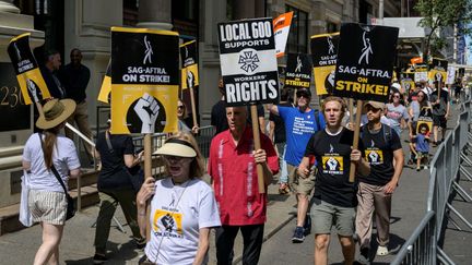 Des membres de la Writers Guild of America et de la Screen Actors Guild tiennent un piquet de grève devant les locaux de Netflix et de Warner Bros. Discovery à New York, le 2 août 2023 (ANGELA WEISS / AFP)