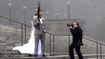 Un couple de jeunes mari&eacute;s pose avec un fusil d'assaut AR-10 sur les marches du capitole &agrave; Olympia (Washington, Etats-Unis), le 13 d&eacute;cembre 2014. (ELAINE THOMPSON / AP / SIPA)