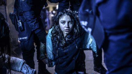 Une jeune manifestante bless&eacute;e lors d'affrontements avec la police en marge des fun&eacute;railles de Berkin Elvan. L'adolescent de 15 ans avait &eacute;t&eacute; bless&eacute; lors de manifestations&nbsp;anti-gouvernementales un an plus t&ocirc;t &agrave; Istanbul (Turquie), le 12 mars 2014. (BULENT KILIC / AFP)