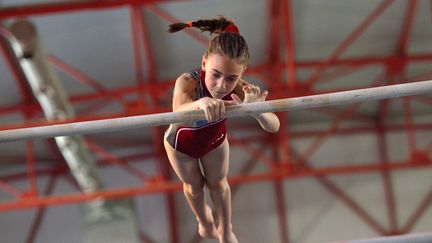 Une gymnaste&nbsp;s'entraîne sur des&nbsp;barres asymétriques, en Roumanie, le 13 mai 2016. (DANIEL MIHAILESCU / AFP)