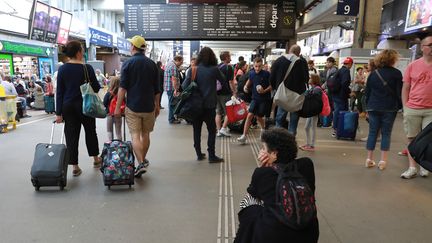 Des voyageurs attendent en gare de Montparnasse le 30 juillet 2017, à Paris.&nbsp; (JACQUES DEMARTHON / AFP)