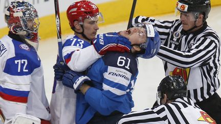 Le Russe&nbsp;Maxim Chudinov&nbsp;(G) &eacute;trangle le Finlandais&nbsp;Maxim Chudinov&nbsp;(D) &agrave; l'occasion de la finale du championnat du monde de hockey sur glace opposant les deux &eacute;quipes &agrave; Minsk (Russie), le 25 mai 2014. (ALEXANDER DEMIANCHUK / REUTERS)