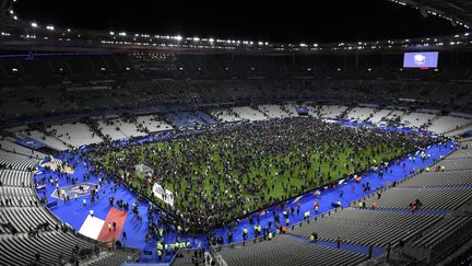 13 novembre 2015. 23h00. À la fin du match, le public du Stade de France est prié de rester en sécurité dans l'enceinte. La pelouse est alors envahie. (FRANCK FIFE / AFP)