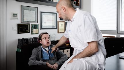 Jérôme Hamon, qui a reçu une greffe au visage, ci-contre avec l'un de ses médecins, le professeur Laurent Lantieri, à l'hôpital européen Georges Pompidou à Paris, le 13 avril 2018. (PHILIPPE LOPEZ / AFP)