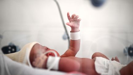 Un nouveau-né est allongé sur un lit après sa naissance à la maternité d'un hôpital à Paris, le 29 juin 2022. (CHRISTOPHE ARCHAMBAULT / AFP)