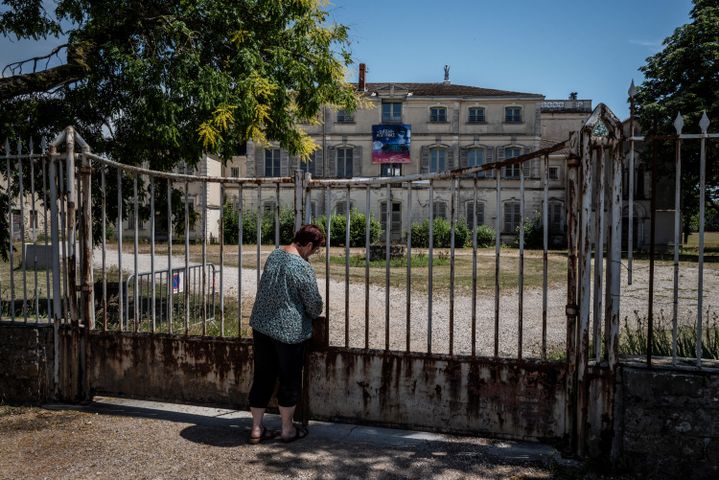 Une personne ouvre la grille très rouillée du château d'enfance d'Antoine de Saint-Exupéry, pionnier de l'aviation et auteur du "Petit Prince". Photo prise le 26 juin 2020. (JEFF PACHOUD / AFP)