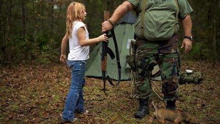 Une enfant de 9 ans, membre d'un "groupe de survie", tend une arme automatique &agrave; son chef, en Floride, le 8 d&eacute;cembre 2012. (REUTERS )