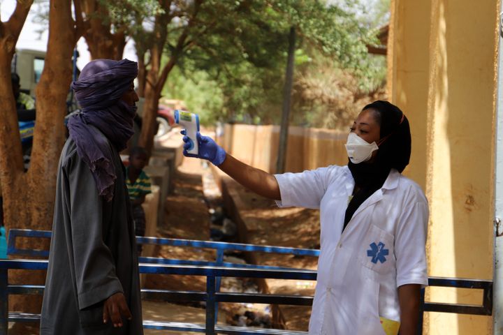 Une infirmière prend la température d'un homme dans le cadre de la campagne contre le coronavirus à Gao au Mali, le 26 mars 2020. (SOULEYMANE AG ANARA / AFP)