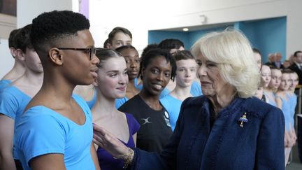 Le danseur nigérian Anthony Madu (à gauche) avec la reine Camilla lors de sa visite à l'Elmhurst Ballet School , à Birmingham, le 14 mars, le 14 mars 2023. (FRANK AUGSTEIN / POOL)