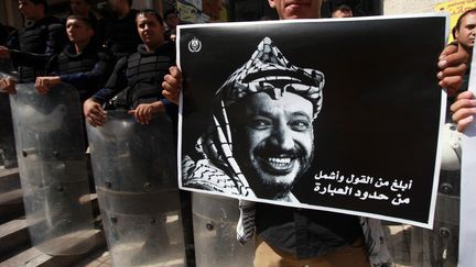 Un Palestinien brandit un portrait de Yasser Arafat, lors d'une manifestation &agrave; Ramallah, en Cisjordanie, le 15 septembre 2013. (ABBAS MOMANI / AFP)