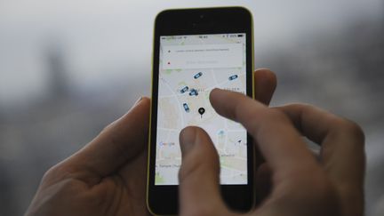 Une personne utilise l'application Uber sur son téléphone, le 28 octobre 2016, à Londres (Angleterre).&nbsp; (DANIEL SORABJI / AFP)