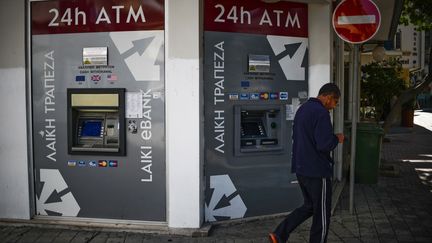 Un homme passe devant des distributeurs automatiques de billets, samedi 23 mars 2013 &agrave; Nicosie (Chypre). (VLADIMIR ASTAPKOVICH / RIA NOVOSTI / AFP)