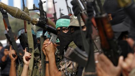 Des membres des brigades Ezzedine Al-Qassam, le bras arm&eacute; du Hamas, c&eacute;l&egrave;brent la tr&ecirc;ve&nbsp;jeudi 22 novembre au camp de r&eacute;fugi&eacute;s de Nusseirat, dans la bande de Gaza. (MOHAMMED ABED / AFP)