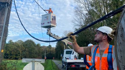 Des ouvriers remplacent les "fils nus" par les câbles torsadés à Brec’h (Morbihan). (LAURIANE DELANOE / RADIO FRANCE)