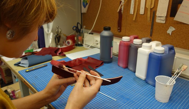 Chez Missiessy, une apprentie-compagnon teint les bordures d'une sangle de sac
 (Corinne Jeammet)