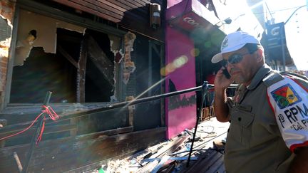 Un policier devant la discoth&egrave;que o&ugrave; s'est d&eacute;roul&eacute;e la trag&eacute;die de Santa Maria (Br&eacute;sil), le 28 janvier 2013. (JEFFERSON BERNARDES / AFP)