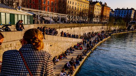 Cette image prise le 6 mars 2021 à Lyon, illustre le non-respect des gestes barrières le long des quais de Saône, à l'heure du couvre-feu. Le retour à la vie "normale" peut effrayer tous ceux qui craignent rassemblements et contamination.&nbsp; (ROBERT DEYRAIL / GAMMA-RAPHO / GETTY IMAGES)