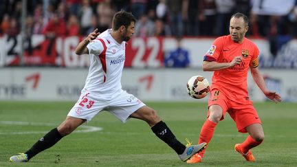 Koke au duel avec Andrés Iniesta lors de Séville-Barça (saison 2014-2015). (CRISTINA QUICLER / AFP)