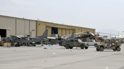 Des avions et des véhicules militaires des forces aériennes afghanes près d'un hangar de l'aéroport de Kaboul, le 31 août 2021. (WAKIL KOHSAR / AFP)