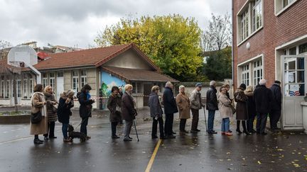 Des électeurs de la primaire à droite patientent dans la cour d'une école, le 20 novembre 2016, à Paris. (JULIEN MATTIA / NURPHOTO)