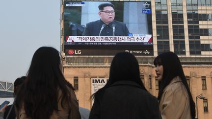 Des habitants de Séoul, en Corée du Sud, suivent le sommet entre&nbsp;Moon Jae-in et Kim Jong-un, vendredi 27 avril. (JUNG YEON-JE / AFP)