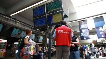 Du personnel de la SNCF guident des usagers à la gare Montparnasse, après l'incendie d'un poste d'alimentation, le 30 juillet 2018. (MAXPPP)