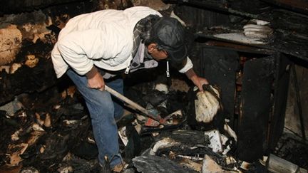 Un homme fouille les débris après l'incendie de la synagogue de La Canée en Crète (Grèce) (AFP/Costas Metaxakis)