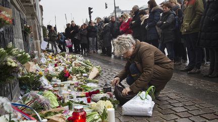 Une personne d&eacute;pose des fleurs devant l'ambassade de France &agrave; Copenhague (Danemark) pendant la minute de silence. (NIELS AHLMANN OLESEN / SCANPIX DENMARK / AFP)