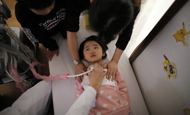 Examen de la thyro&iuml;de d'une petite fille de 5 ans &agrave; Nihonmatsu, dans la pr&eacute;fecture de Fukushima (Japon), le 27 f&eacute;vrier 2014. (TORU HANAI / REUTERS)