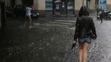 Des passants sous la pluie lors d'un orage à Nantes (Loire-Atlantique), le 9 juillet 2017. (MAXPPP)