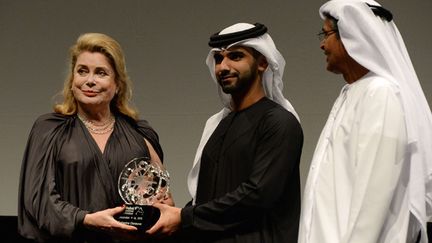 Catherine Deneuve reçoit une distinction pour l'ensemble de sa carrière au  festival du film de Dubaï, des mains de Sheikh Mansour bin Mohammed al-Maktoun (au centre), le 9 décembre 2015
 (Martin Dokoupil / AP / SIPA)