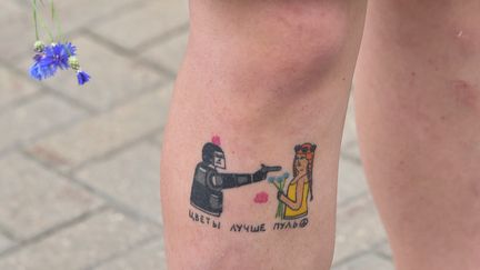 Une manifestante biélorusse arbore un tatouage "les fleurs sont mieux que les balles" pour protester contre les violences du régime, le 12 août 2020. (SERGEI GAPON / AFP)