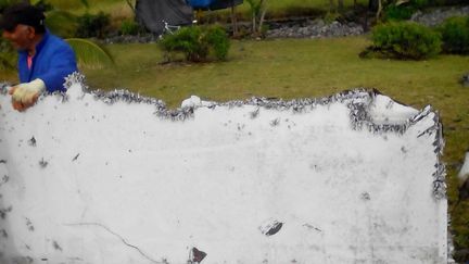 Un fragment d'aile retrouvé sur l'île française de La Réunion, dans l'océan Indien, et appartenant, selon les autorités malaisiennes et la justice française, au Boeing 777 de Malaysia Arlines, le 6 août 2015. (ROMAIN LATOURNERIE / NURPHOTO / AFP)