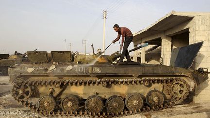 Un homme nettoie un char &agrave; Azaz pr&egrave;s d'Alep (Syrie), le 20 mai 2013. (MUZAFFAR SALMAN / REUTERS)