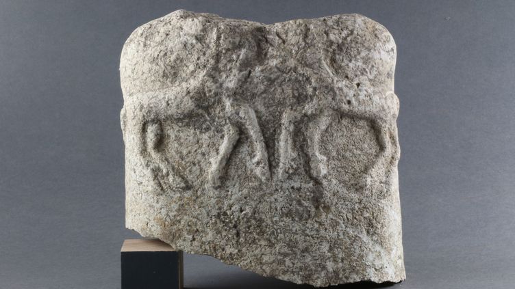 Un fragment de statue de style celtique représentant un torse humain. Au dos sont sculptés deux animaux en plein combat. (© Mathilde Noel, Inrap)