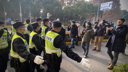 La police éloigne les journalistes réunis à l'extérieur du tribunal de Shanghai (Chine) où est jugée Zhang Zhan, le 28 décembre 2020. (LEO RAMIREZ / AFP)