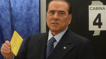 L'ancien Premier ministre, Silvio Berlusconi, d&eacute;pose son vote dans l'urne, le 24 f&eacute;vrier 2013, &agrave; Milan (Italie). (OLIVIER MORIN / AFP)