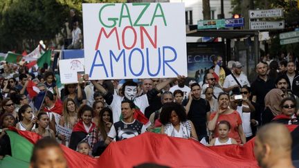 Dans le cort&egrave;ge, mercredi 23 juillet,&nbsp;des sympathisants &eacute;taient rev&ecirc;tus d'un drapeau palestinien ou de keffiehs, d'autres tenait des pancartes avec l'inscription "Gaza mon amour".&nbsp; (KENZO TRIBOUILLARD / AFP)