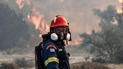 Un pompier à côté d'un incendie près du village de Vati dans la partie sud de l'île grecque de Rhodes, le 25 juillet 2023. (SPYROS BAKALIS / AFP)