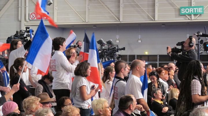 Des grappes de jeunes populaires, le jeunes UMP sont r&eacute;partis un peu partout dans le public, notamment devant les cam&eacute;ras. Ils sont bien visibles avec leur tee-shirts blancs. (SALOME LEGRAND / FTVI)