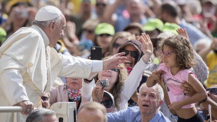 Le pape François est accueilli par la foule lors de son audience hebdomadaire place Saint-Pierre, au Vatican, le 13 juin 2018. (MASSIMO VALICCHIA / NURPHOTO / AFP)