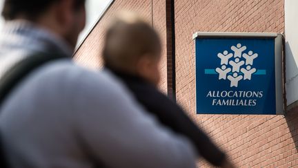 Un p&egrave;re et son enfant devant l'agence de la caisse d'allocations familiales de&nbsp;Tourcoing (Nord),&nbsp;le 30 septembre 2014. (PHILIPPE HUGUEN / AFP)