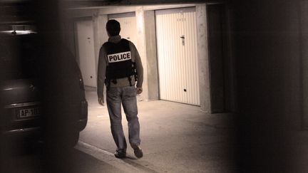 Un policier fouille le box d'un parking appartenant &agrave; l'un des suspects arr&ecirc;t&eacute;s lors du coup de filet antiterroriste, le 9 octobre 2012 &agrave; Torcy (Seine-et-Marne).&nbsp; (MEHDI FEDOUACH / AFP)