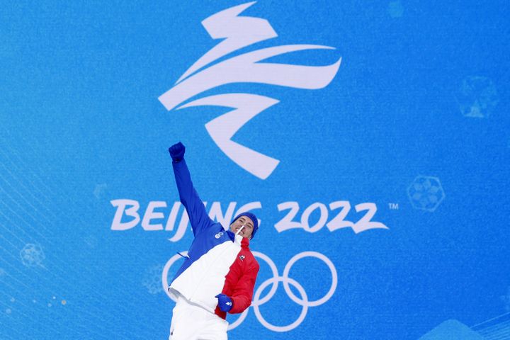 Quentin Fillon Maillet laisse exploser sa joie au moment de monter sur la première marche du podium pour recevoir sa médaille d'or aux Jeux olympiques de Pékin, le 9 février 2022. (ODD ANDERSEN / AFP)