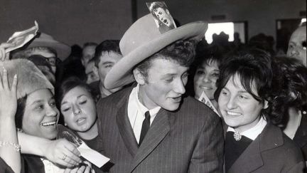 Sous un grand chapeau, le chanteur est accueilli&nbsp;par ses fans à l'aéroport d'Orly, près de Paris, le 12 octobre 1968. (MAXPPP)