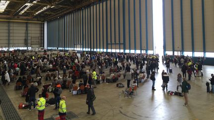 Des&nbsp;passagers sont assis bloqués dans un hangar à l'aéroport de Zaventem, le 22 Mars, 2016, après les attentats terroristes de Bruxelles (CITIZENSIDE / FABRICE DEKONINCK / AFP)