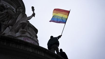 Un drapeau arc-en-ciel, symbole du mouvement LGBTQ+ et de la lutte contre l'homophobie, en haut de la statue de la République, à Paris, le 31 janvier 2021. (LOU OSRA / HANS LUCAS / AFP)