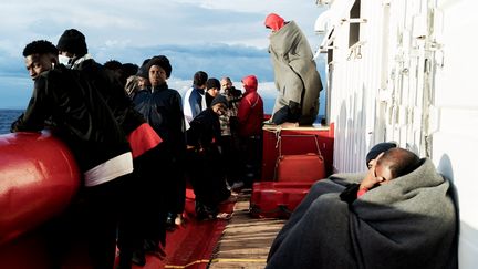 Des migrants sur le pont du navire de sauvetage de l'Ocean Viking, bateau SOS Méditerranée dans le golfe de Catane en mer Méditerranée, le 6 novembre 2022. (VINCENZO CIRCOSTA / AFP)